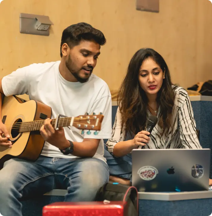 Colleagues playing guitar and singing together